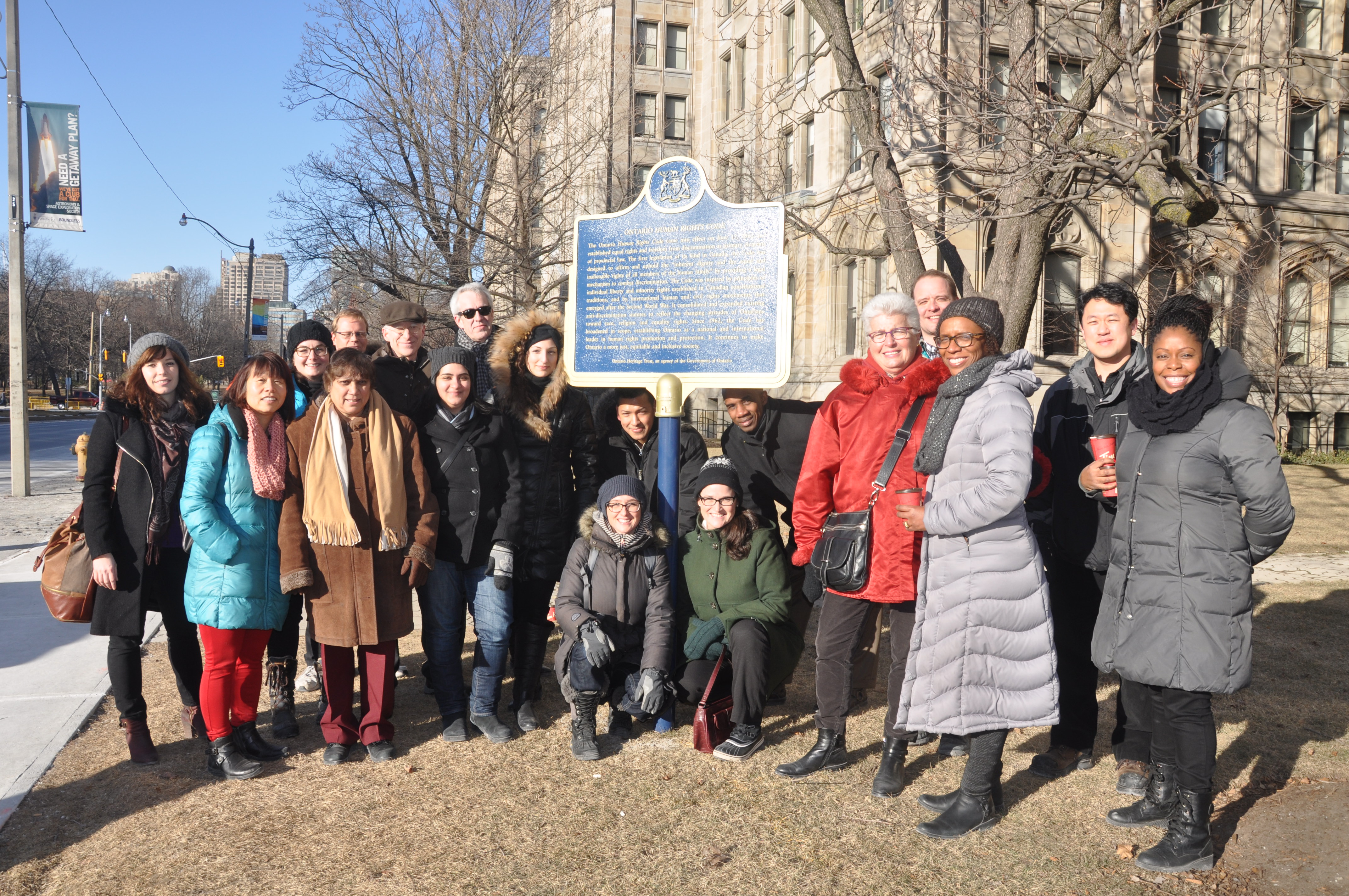 Chief Commissioner Barbara Hall and Executive Director Diane Carter stand with OHRC staff in a semi-circle around the Human Rights Code Plaque at Queens Park.
